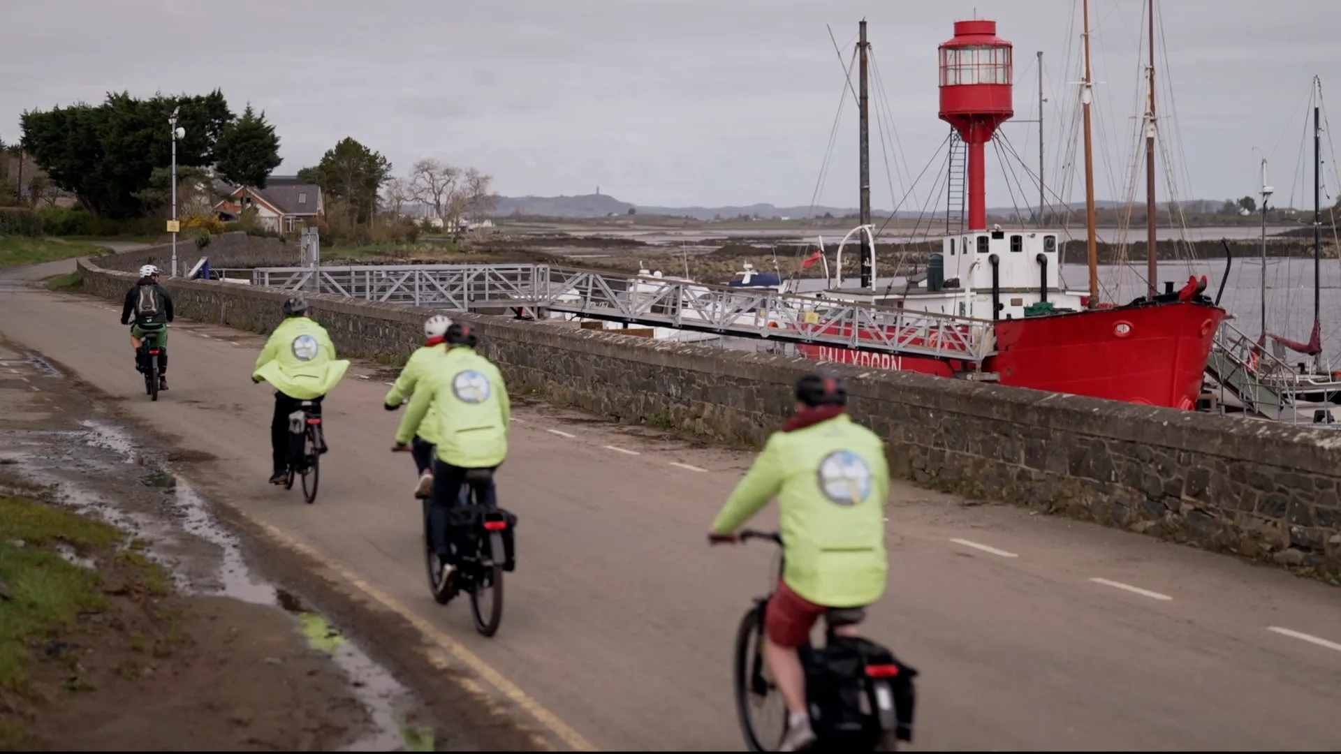 3 people riding e-bikes wearing hi-vis jackets