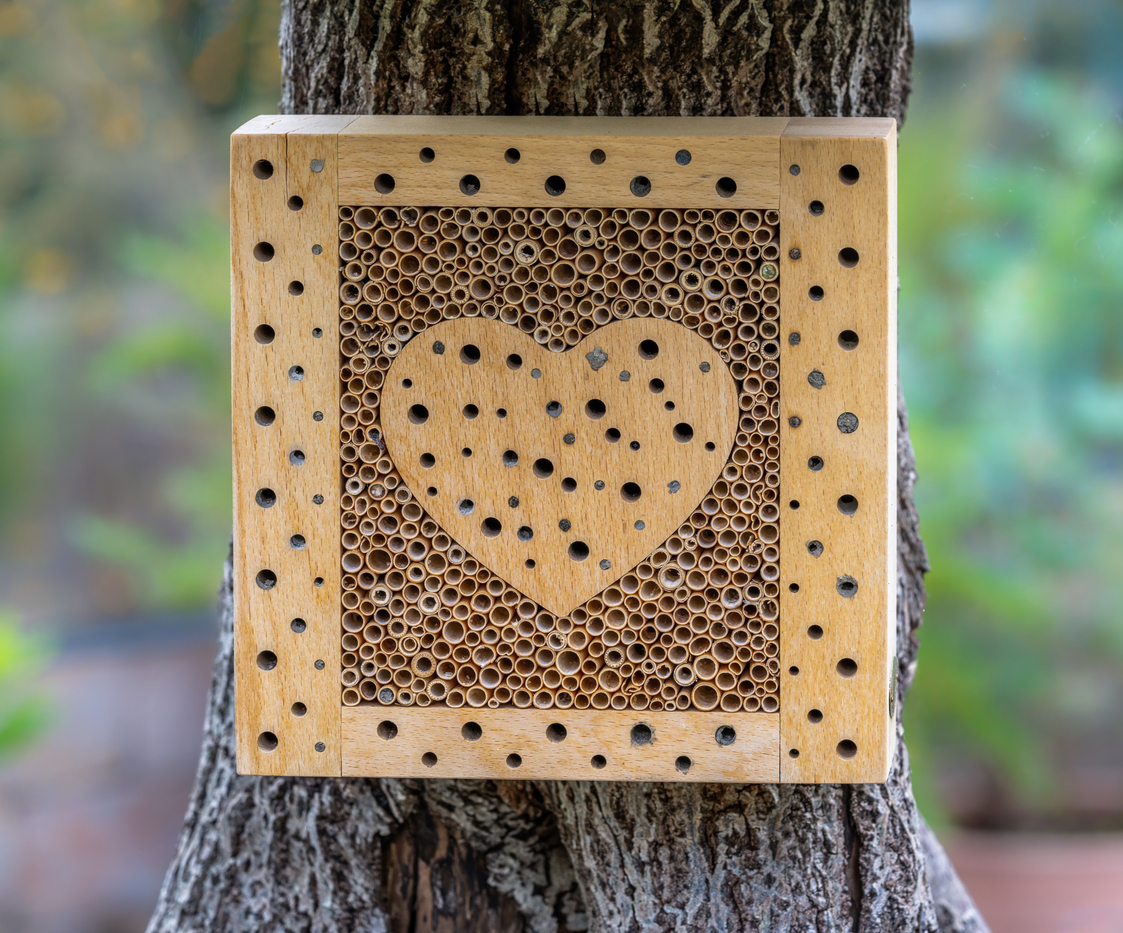 a wooden insect hotel with a heart