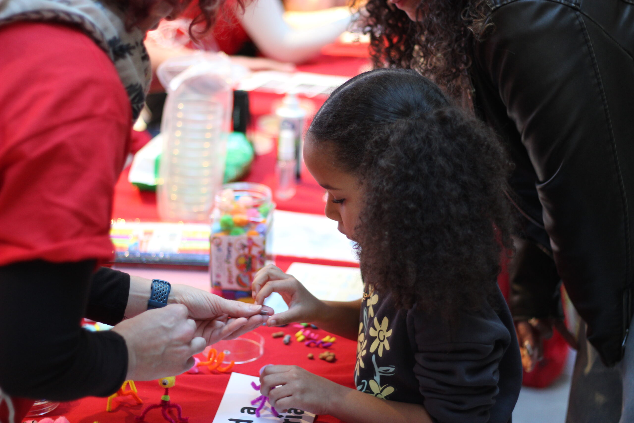 A child being shown a small pill at an exhibition table